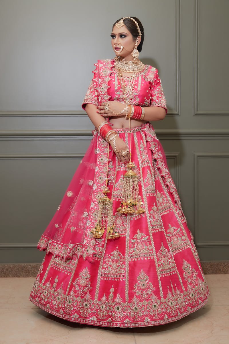 Elegant Indian bride wearing a vibrant pink lehenga, adorned with intricate embroidery, showcasing cultural heritage.